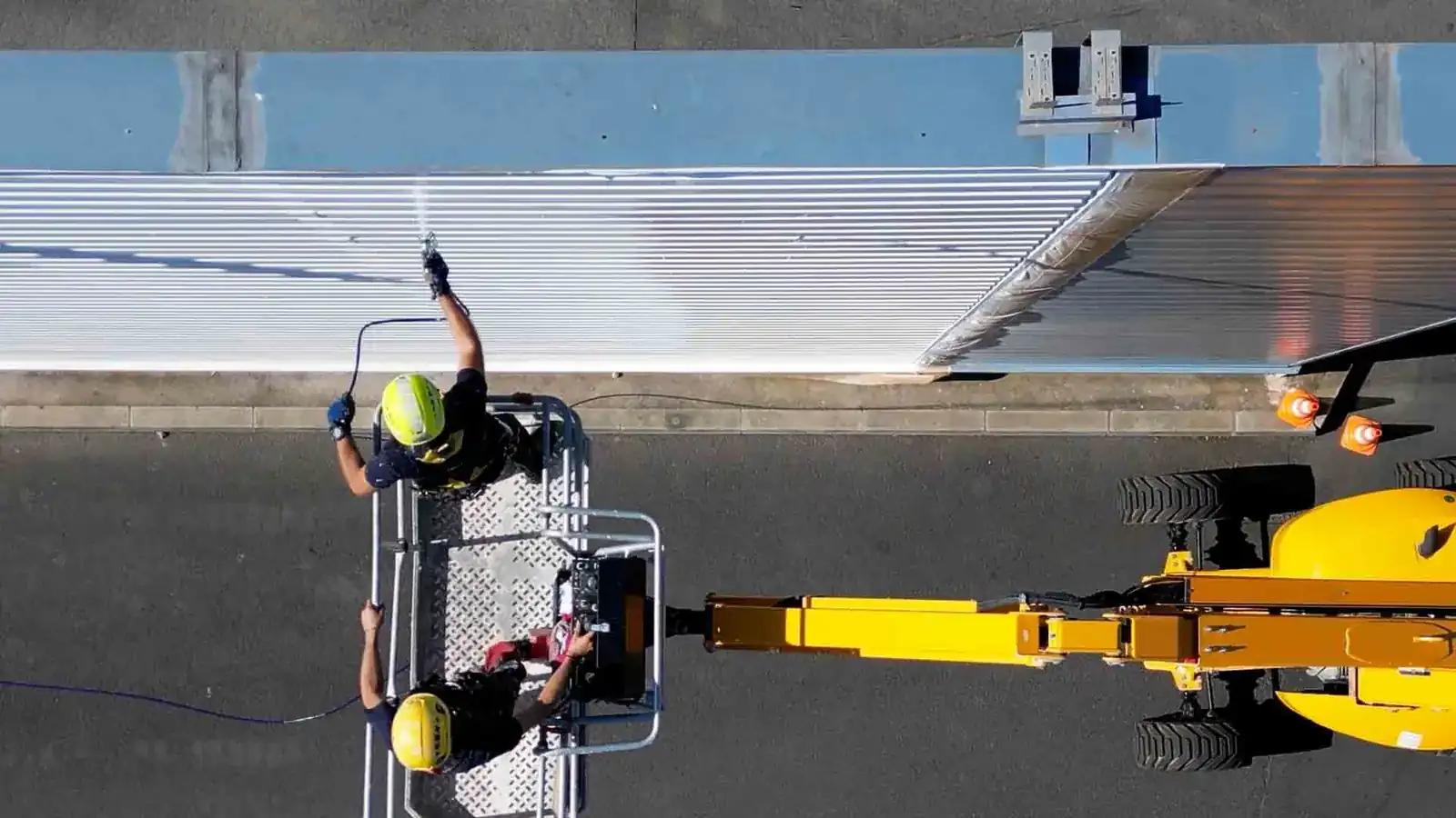 Pulvérisation de peinture sur bardage métallique par cordiste professionnel